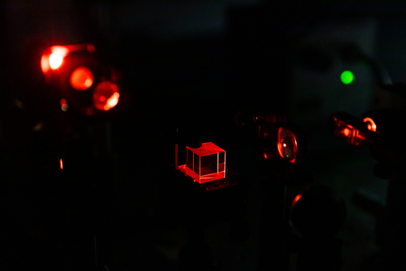 Часть оптической схемы, формирующей подсветку красным широким световым пучком. Зеленое пятно — лампочка-индикатор включенного лазера. Фото: Дмитрий Григорьев / ITMO.NEWS
