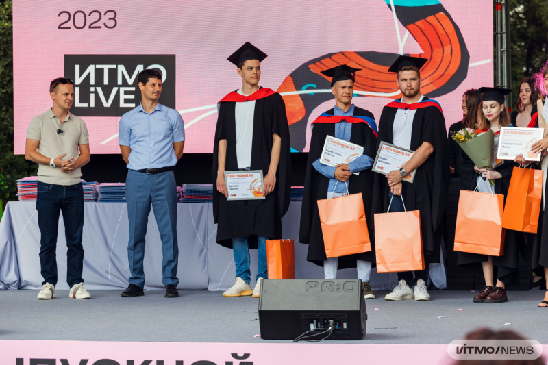 (left to right) Vadim Zayats, Mikhail Telegin, and graduates at ITMO.LiVE 2023. Photo by Dmitry Grigoryev / ITMO.NEWS
