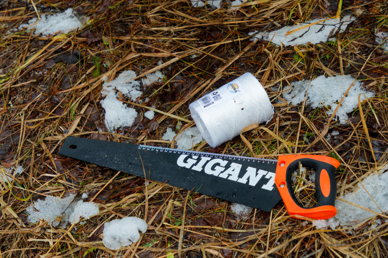 The saw and twine packed along with other tools in preparation to harvest the fir tree