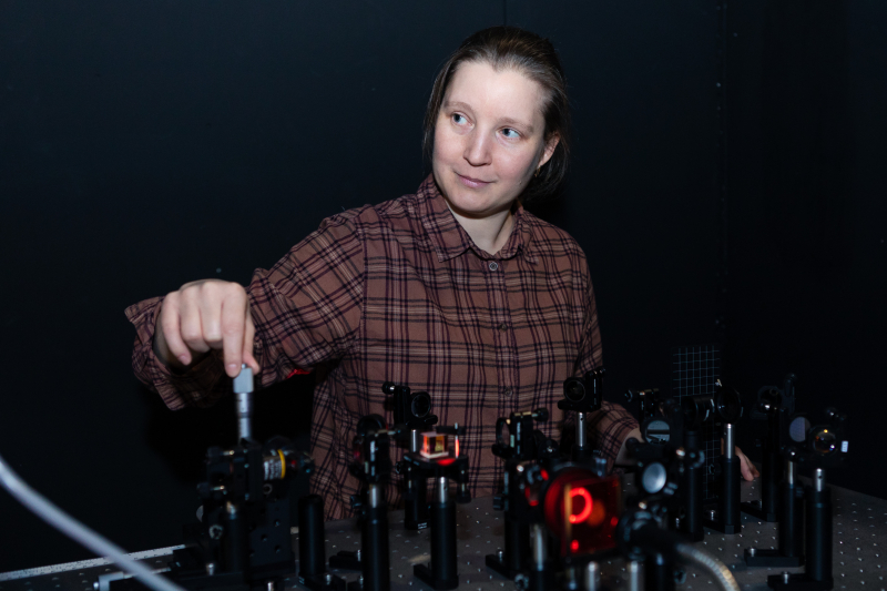 Tatiana Orlova setting up a liquid crystal sample relatively to a passing focused Gaussian ultraviolet beam to get a spot of light of the necessary diameter. The diameter is defined by the distance between the focusing lens and the sample. The beam itself is invisible and the red light is used to visualize the systems created by the beam in the sample. Photo by Dmitry Grigoryev, ITMO.NEWS 
