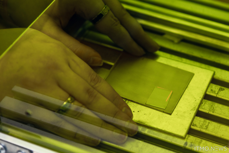 Inside the laser-proof protective box, the glass is put on a titanium plate and then treated with laser-generated plasma from one side. As a result, a layer of auxiliary particles forms on the surface, increasing its adhesion. Photo by Dmitry Grigoryev, ITMO.NEWS
